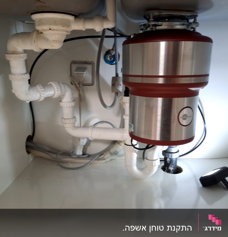 צנרת מתחת לכיור עם טוחן אשפה מתכת